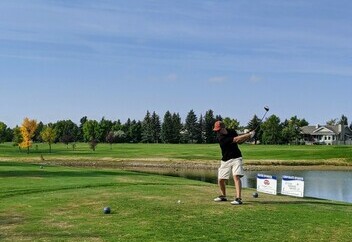 golfer driving a golf ball at golf course