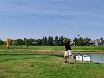 golfer driving a golf ball at golf course